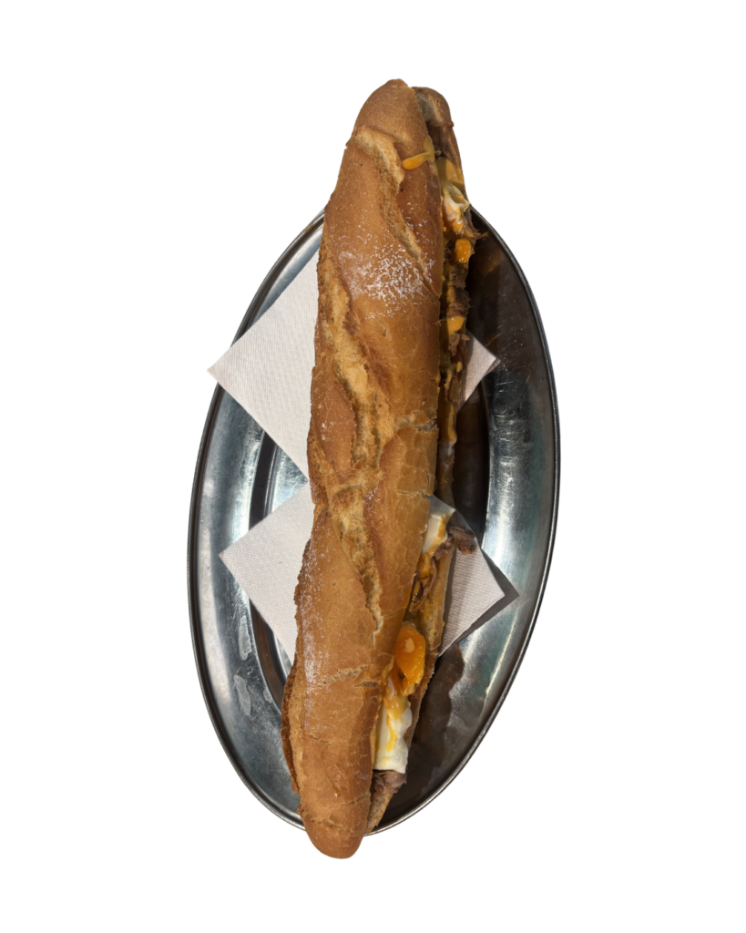 Bocadillo Brascada con carne de caballo, cebolla a la plancha y jamón, servido en pan crujiente.