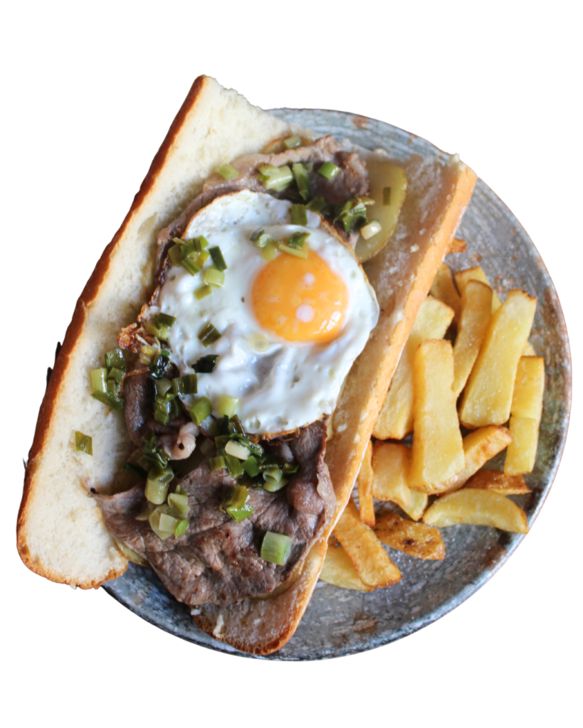 Bocadillo Caballito con carne de caballo, huevo frito, patatas y ajos tiernos.