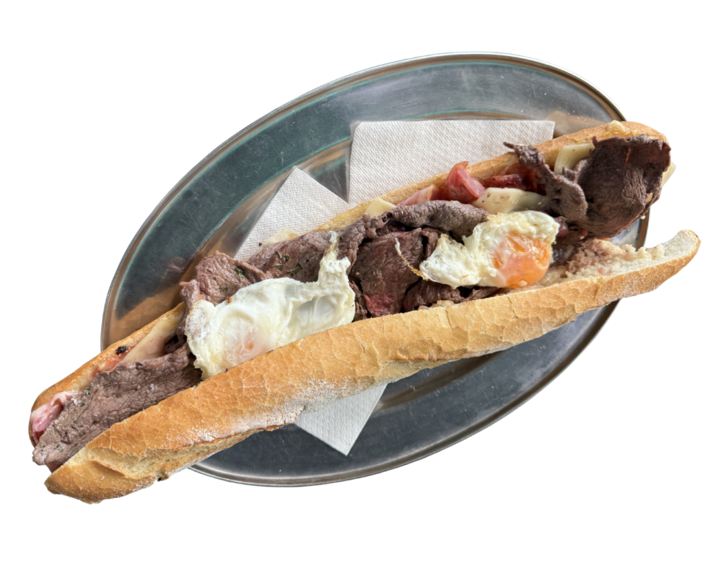 Chivito Durban con lomo, bacon, tomate, lechuga, mayonesa y huevo frito. Title: Chivito Durban - Carta de Bocadillos