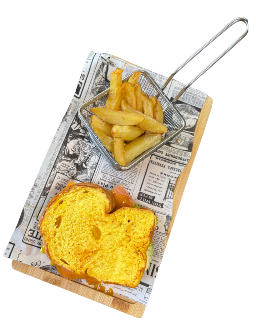 Sándwich Cremosito con mantequilla, salmón, aguacate, coulis de mango, queso edam y queso Philadelphia, acompañado de patatas fritas.