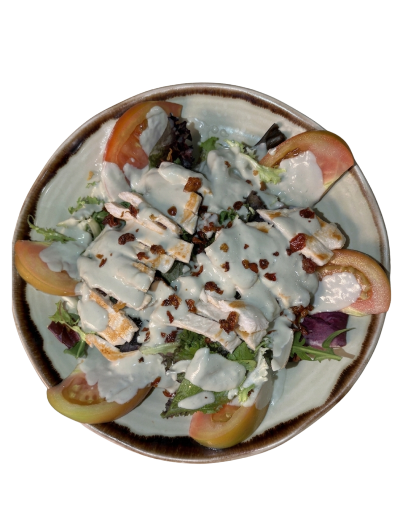 Ensalada London con pollo a la plancha, bacon crujiente, tomate raff y salsa roquefort.