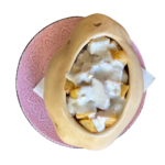 Patatas con Cabrales a la sidra, servidas en un cuenco de barro.