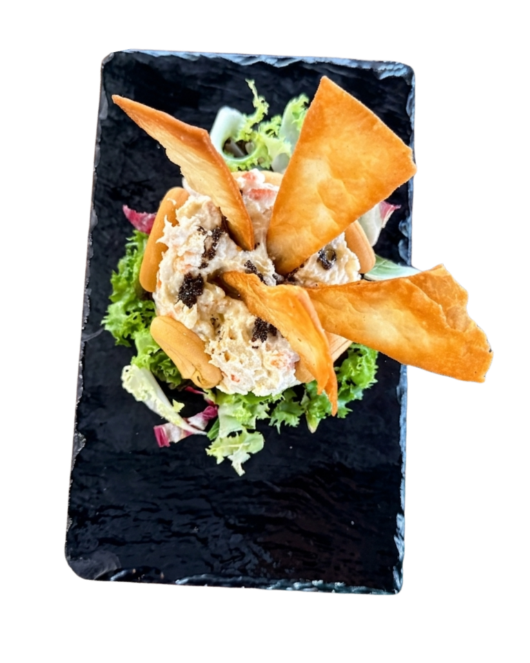 Timbal de ensaladilla rusa con crujientes triángulos de pasta, servido sobre una cama de lechuga.