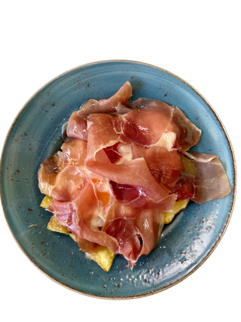 Huevos rotos trufados con jamón de Teruel, patatas a lo pobre y un toque de aceite de trufa.