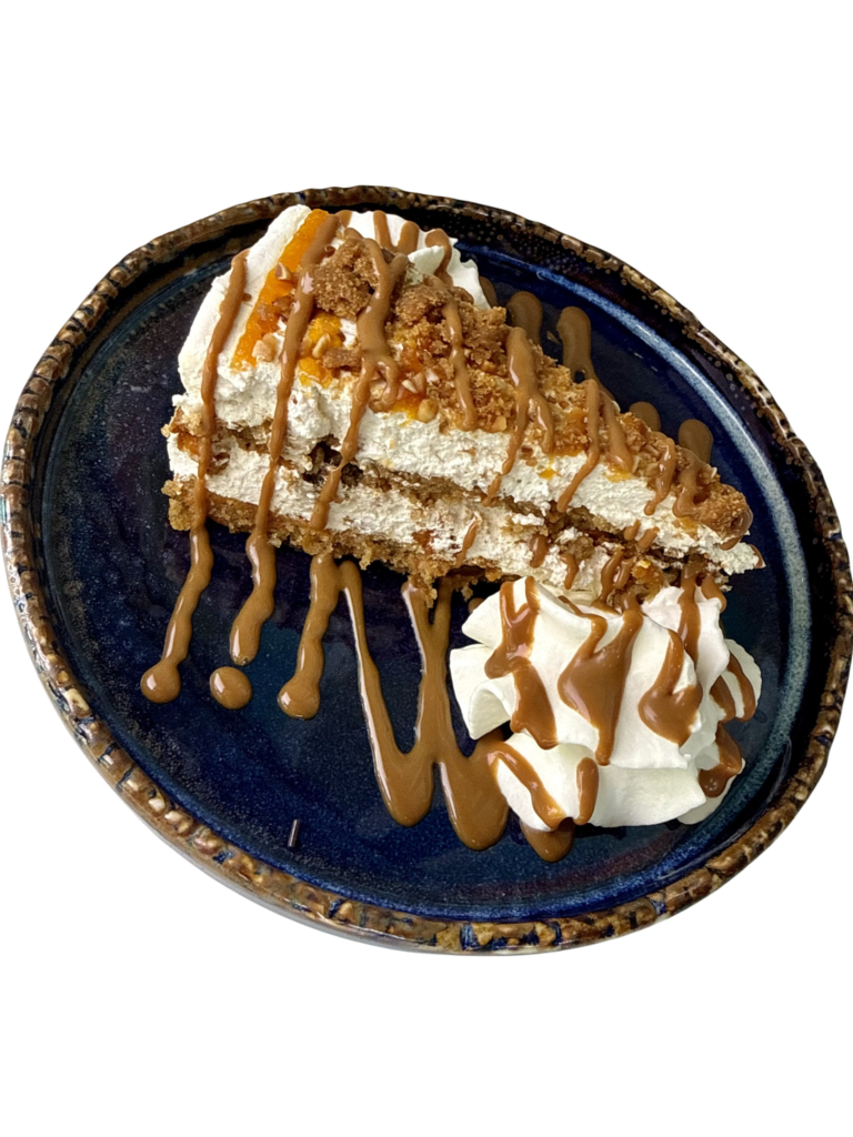 Tarta de zanahoria con frosting de Philadelphia y mascarpone, decorada con trozos de galleta y sirope de caramelo.